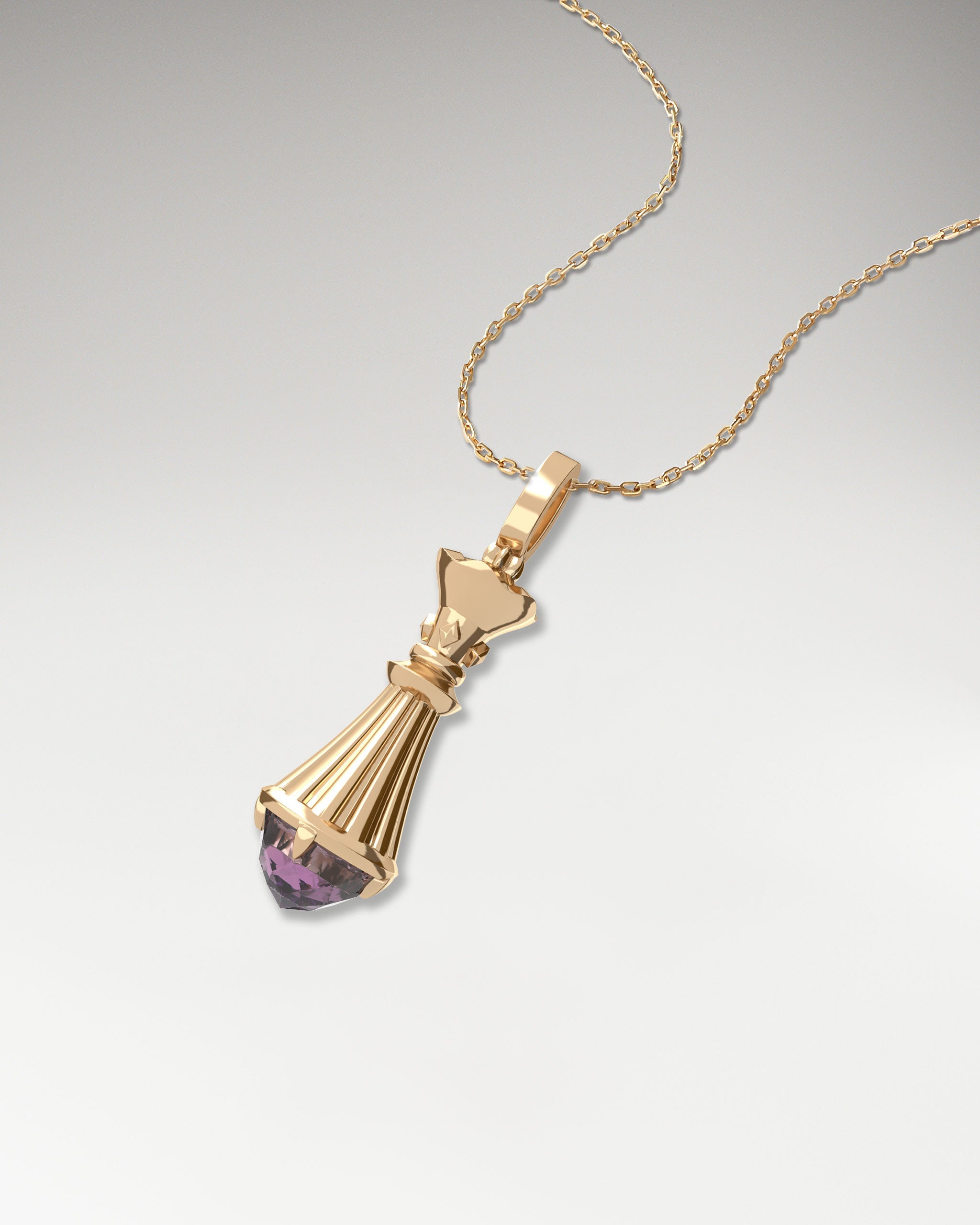 10k gold chess queen pendant featuring a spinel gemstone.