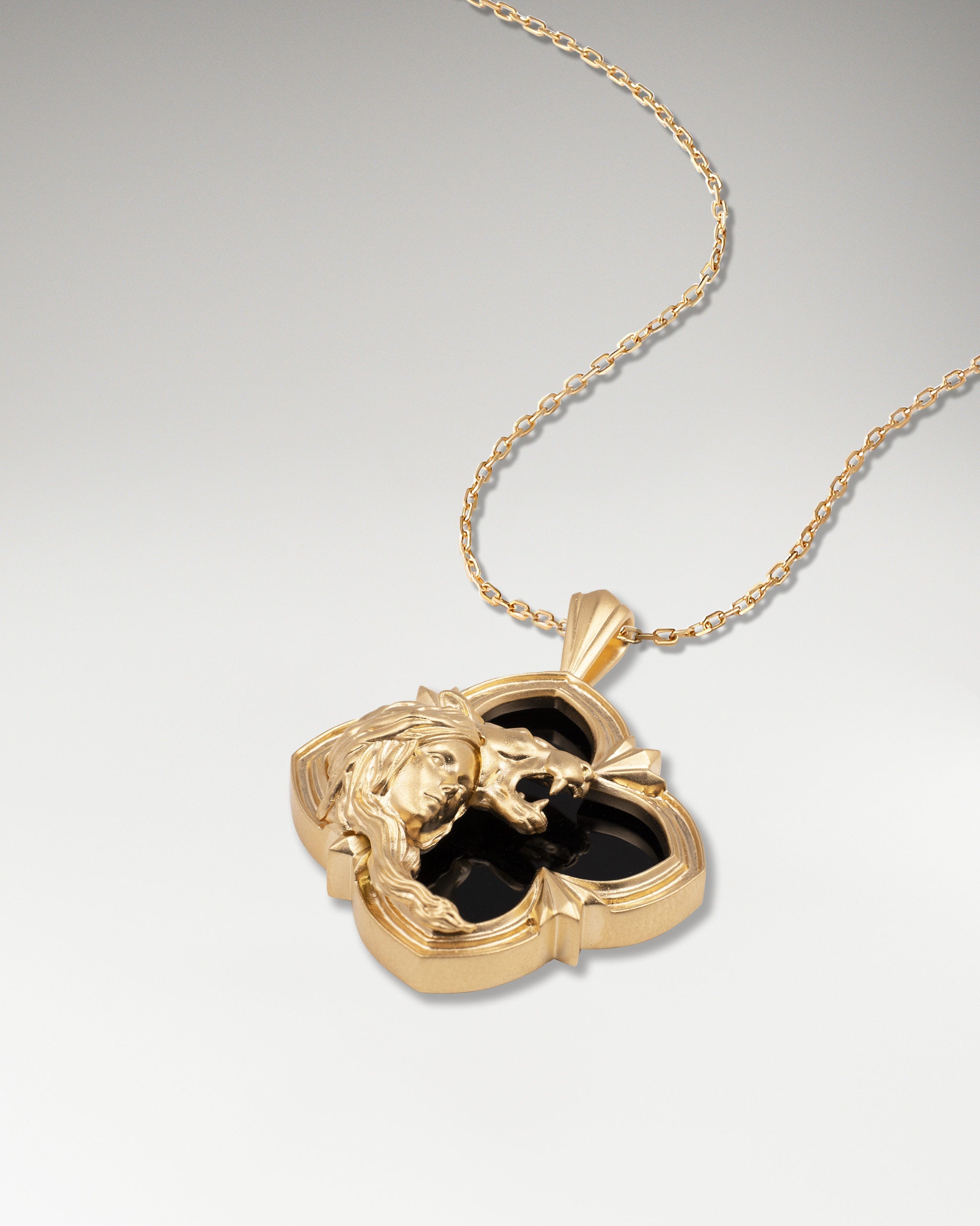 Gold pendant necklace with black agate in a wild encounter design.